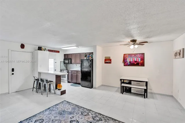 a living room with furniture and kitchen view