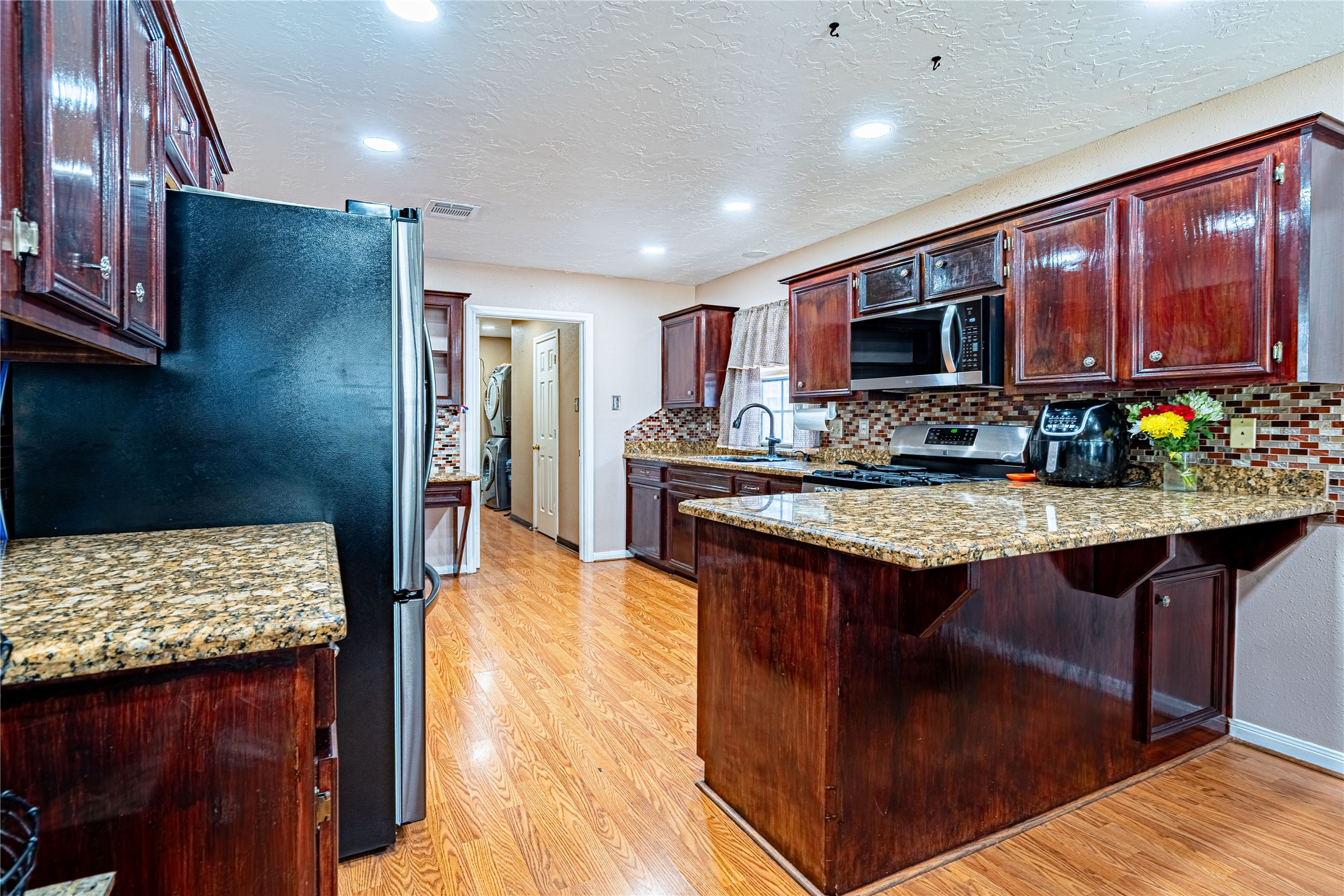 3403 Berry Grove Drive Spring, TX 77388 - Photo 13 of 43 a kitchen with stainless steel appliances granite countertop a stove refrigerator and a sink