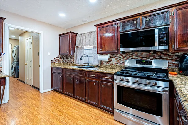 a kitchen with stainless steel appliances a stove microwave and cabinets
