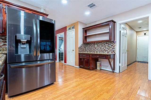 a kitchen with stainless steel appliances granite countertop a refrigerator and a stove top oven
