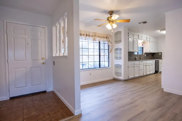 a view of a hallway with wooden floor and a chandelier