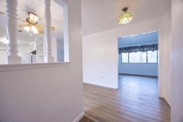 a view of a hallway with wooden floor and staircase