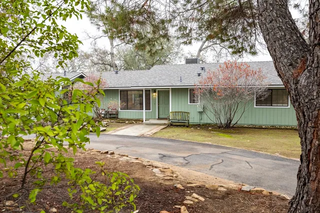 a backyard of a house with barbeque oven and wooden fence