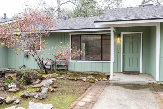 a front view of house with yard and trees around