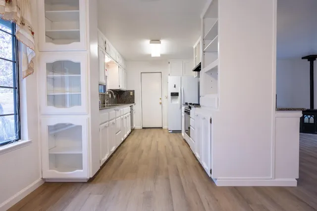 a view of a hallway with wooden floor and closet area
