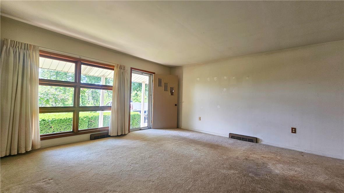 2529 Ringhoffer Road Hellertown, PA 18055 - Photo 4 of 33 A well-lit living area features a large window overlooking a lush green hedge and a welcoming entrance.