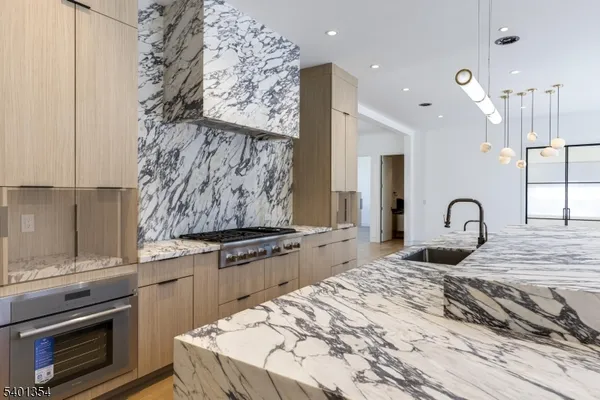 a kitchen with stainless steel appliances granite countertop a stove a sink and a refrigerator