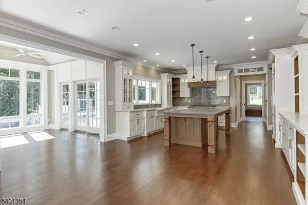 an open kitchen with white cabinets and refrigerator