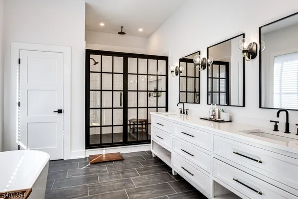 a bathroom with a double vanity sink a mirror and a bathtub