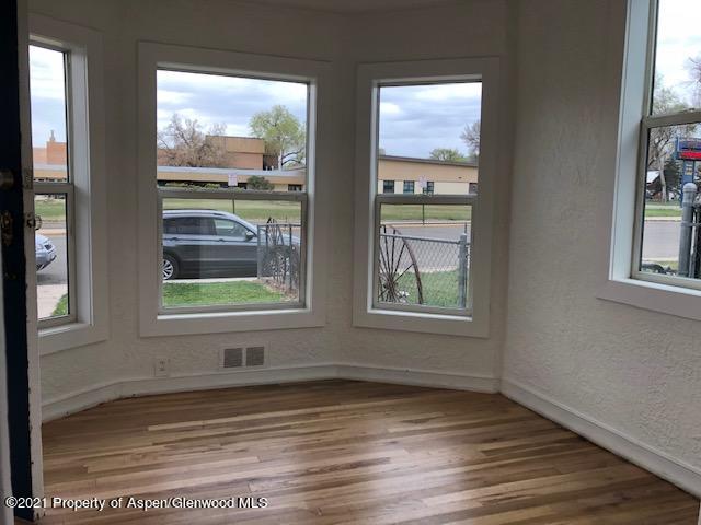 121 West 6th Street Rifle, CO 81650 - Photo 2 of 8 an empty room with wooden floor and windows