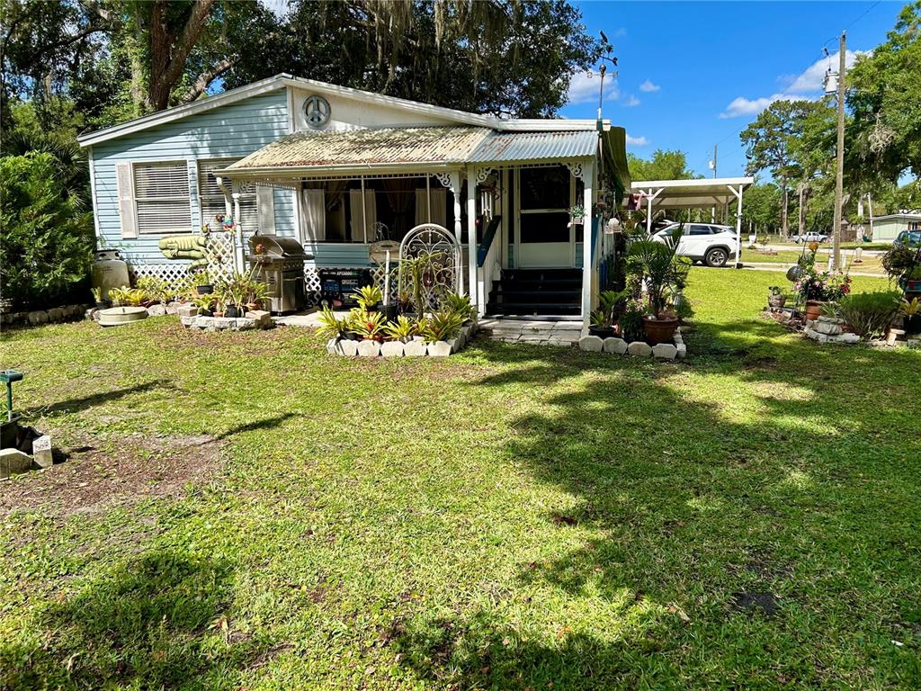 25646 Bass Road Astor, FL 32102 - Photo 40 of 48 a view of a house with backyard sitting area and garden