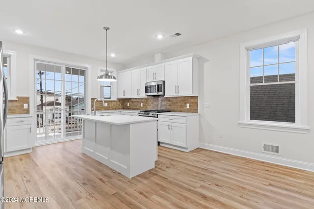 a kitchen with stainless steel appliances granite countertop a stove a sink and a microwave