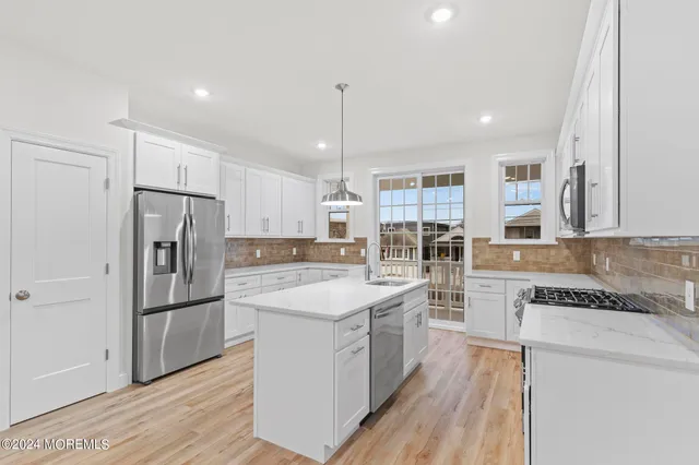 a kitchen with refrigerator a sink and wooden floor