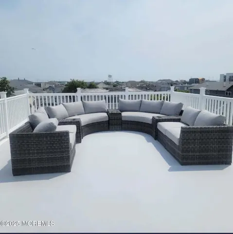 a roof deck with couches and potted plants