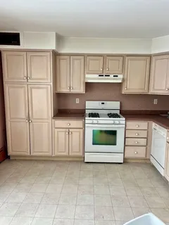 a kitchen with white cabinets and appliances