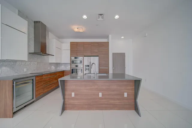 a kitchen with kitchen island granite countertop wooden cabinets and white appliances