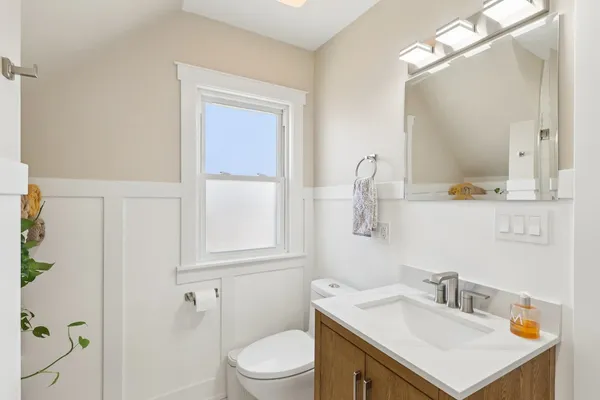 a bathroom with a sink vanity toilet and a mirror