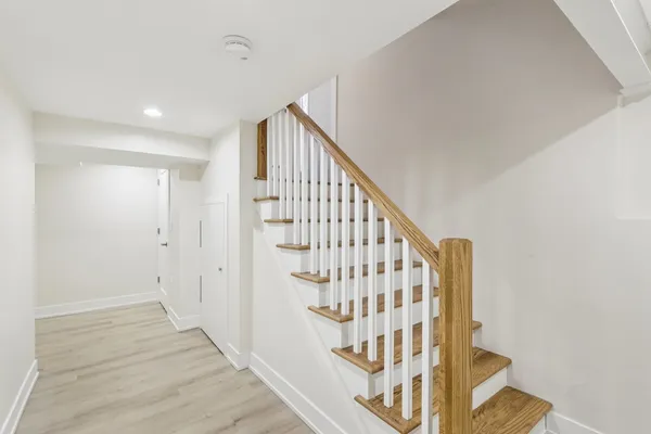 a view of staircase with wooden floor and white walls