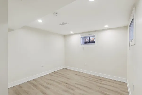 an empty room with wooden floor and window