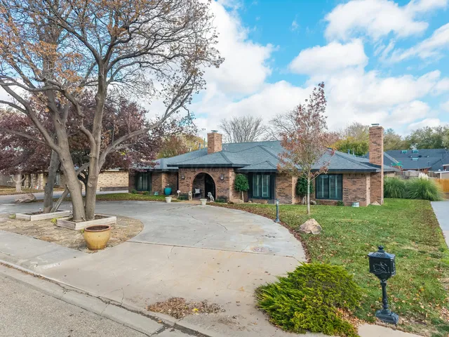 a front view of a house with a yard and trees