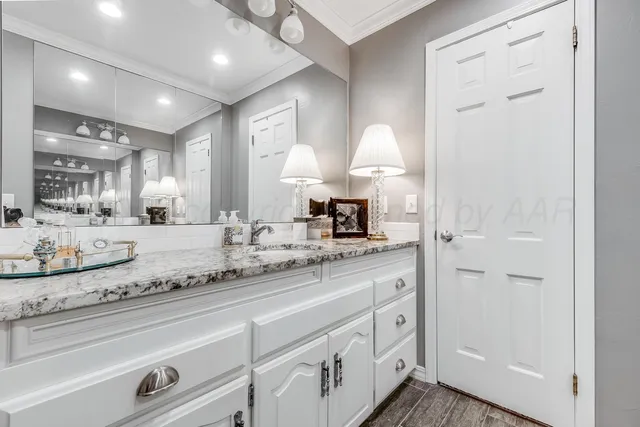 a bathroom with a granite countertop sink double vanity and a mirror