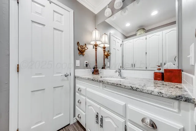 a bathroom with a granite countertop sink a toilet and a mirror