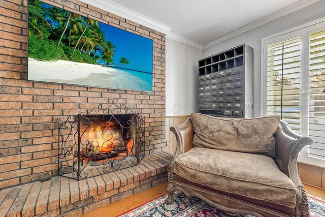 a view of a livingroom with furniture a fireplace and wooden floor