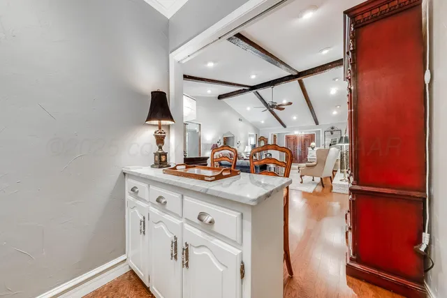 a dining room with wooden floor a chandelier a wooden table and chairs