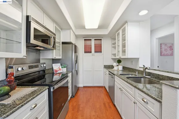 a kitchen with stainless steel appliances granite countertop a sink stove and refrigerator