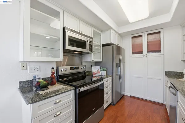 a kitchen with stainless steel appliances granite countertop a refrigerator stove and microwave