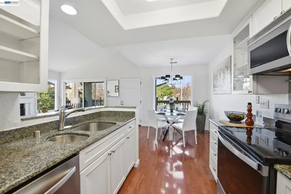 a kitchen with stainless steel appliances granite countertop a sink stove and cabinets