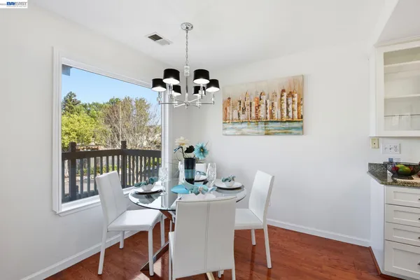 a view of a dining room with furniture a chandelier and wooden floor
