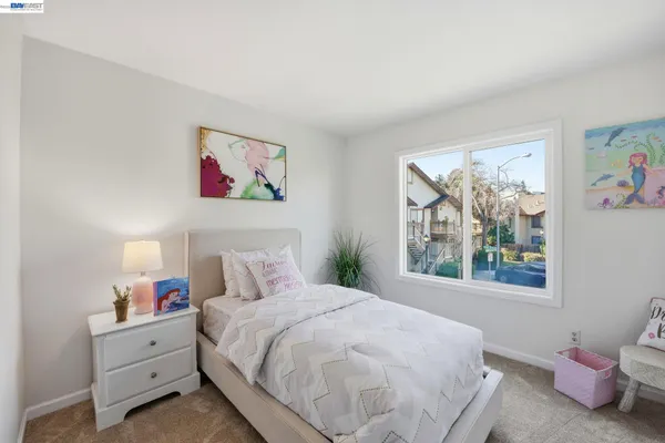 a bedroom with a bed and a painting on the wall