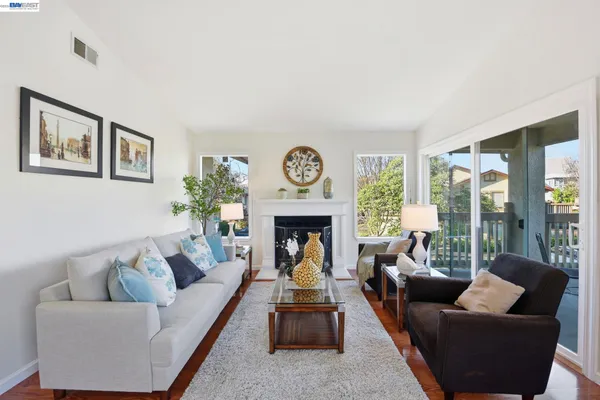 a living room with furniture a fireplace and a floor to ceiling window