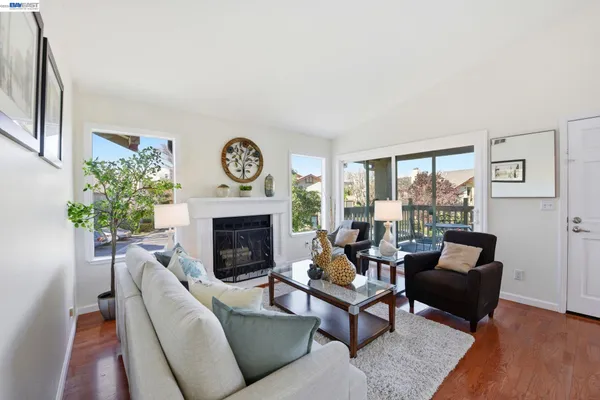 a living room with furniture a large window and a fireplace