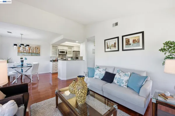 a living room with furniture kitchen view and a window