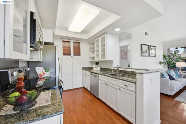 a kitchen with stainless steel appliances granite countertop sink stove top oven and cabinets