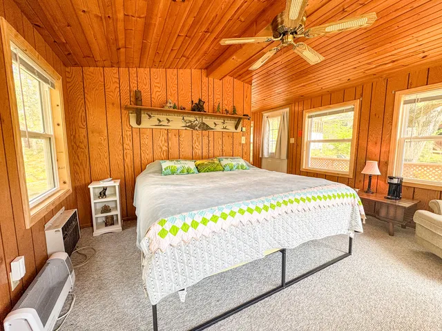 a bedroom with a bed window and table