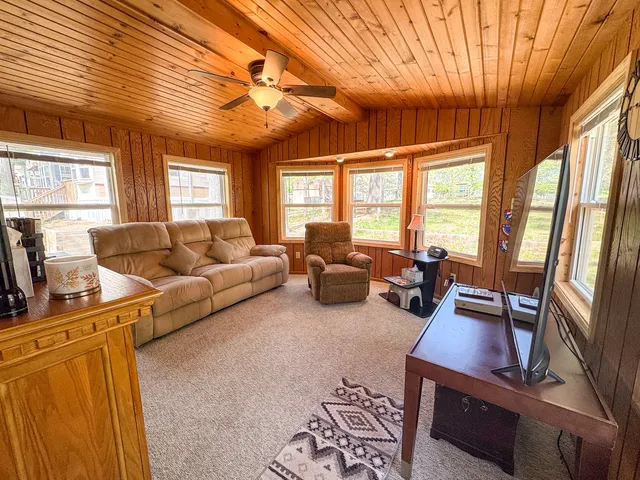 a living room with furniture a flat screen tv and a floor to ceiling window
