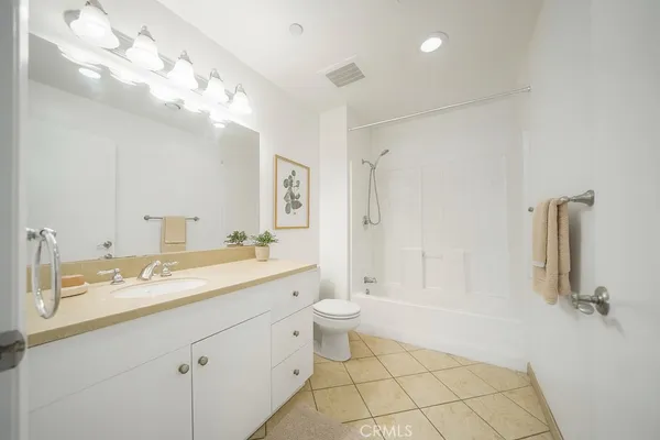 a spacious bathroom with a double vanity sink toilet mirror and shower