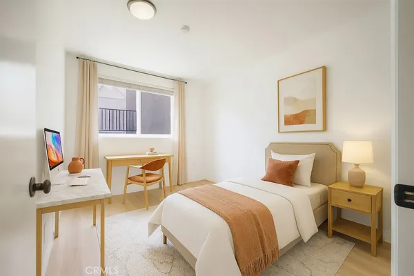 a bedroom with a bed and a flat tv screen on the dresser