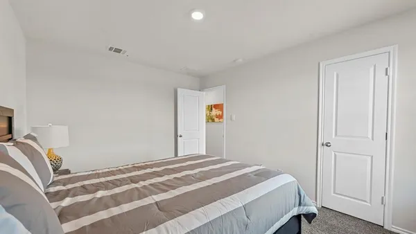 a bedroom with a bed and a painting on the wall