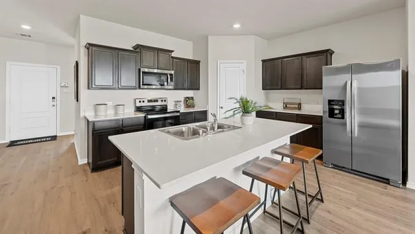 a kitchen with granite countertop a sink appliances and cabinets