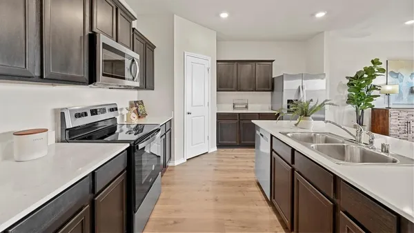a kitchen with furniture wooden floor and stainless steel appliances