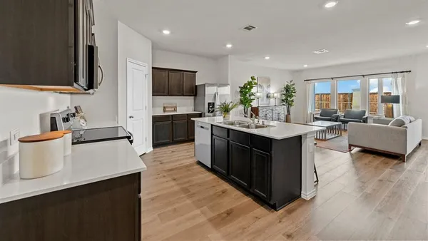 a kitchen with stainless steel appliances a sink stove top oven and refrigerator
