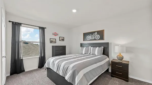 a bedroom with a bed and a large window