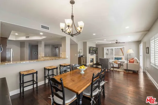 a view of a dining room and livingroom with furniture wooden floor a chandelier