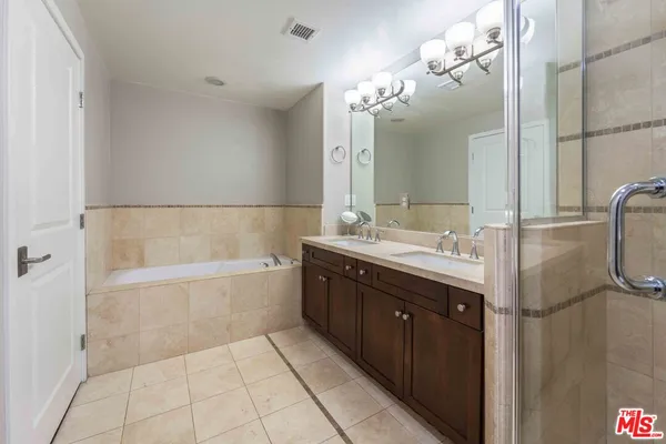 a bathroom with a bathtub sink vanity granite and a mirror