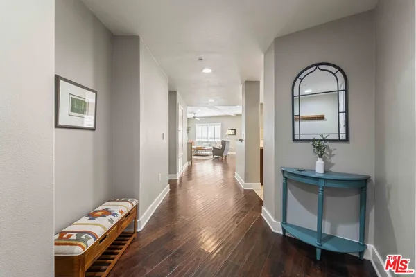 a view of a hallway to a livingroom and a dinning room with wooden floor
