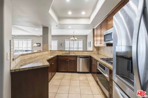 a large kitchen with granite countertop a stove a sink dishwasher and a refrigerator